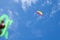 Multicolored kite on the background of the blue sky with clouds