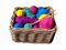 Multicolored knitting yarn balls and needles in wicker basket