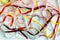 multicolored narrow satin ribbons spread out in a chaotic manner on a white background.