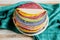 Multicolored pancakes folded in the form of a cake on plate
