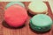 Multicolored pasta cakes in a stack on a wooden board.