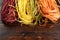 Multicolored pasta on wooden background