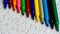 A multicolored pen on a white jigsaw background, color drawing device