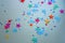 Multicolored plastic stars confetti isolated on a grey shimmer background. Party, Christmas, New Year decoration