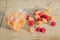 Multicolored raspberries in a glass jar on old wooden background