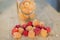 Multicolored raspberries in a glass jar on old wooden background