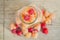 Multicolored raspberries in a glass jar on old wooden background