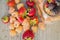 Multicolored raspberries in a glass jar with strawberries on background