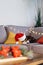 Multicolored relaxed cat lying on a gray sofa in a Santa's hat with blurred Christmas decor composition on the