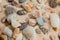 Multicolored river pebbles stones randomly lie on the sand next to the sea. Macro photography. Close-up background concept, copy