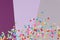 Multicolored round confetti scattered on abstact gray, lilac and violet background