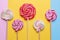 Multicolored round lollipops on a stick on colored bright backgrounds.