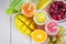 Multicolored smoothies in bottles of mango, orange, banana, celery, berries, on a wooden table.