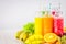 Multicolored smoothies in bottles of mango, orange, banana, celery, berries, on a wooden table.