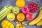 Multicolored smoothies in bottles of mango, orange, banana, celery, berries, on a wooden table.