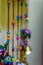 A multicolored spherical objects being hanged from red ropes . A toy for babies. Portrait view