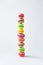Multicolored stacked macarons on white background