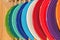 Multicolored stoneware plates displayed in wooden cabinet display case - selective focus