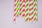 Multicolored straws on the pink background