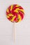 Multicolored swirl lollipop on stick.