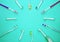 Multicolored toothbrushes on a turquoise background with copy space