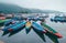 Multicolored traditional rowboats on the morning lake water in Pokhara, Gandaki Pradesh, Nepal. Asian traveling concept image