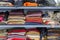 Multicolored various clothes stacked in piles on a shelf