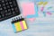 Multicolored various notes or sticky post-it on the background of a wooden office table and office supplies. workplace.