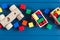 Multicolored wooden blocks, cars, train on blue background. Trendy eco-friendly puzzle toys.  Educational toys for kindergarten,