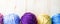 Multicolored woolen balls on wooden background. Banner.