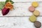 Multicoloured macaroons with roses on a white wooden background