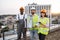 Multicultural designers with equipment posing on rooftop