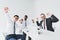 multicultural excited businessmen looking at camera while sitting at workplace