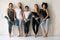 Multicultural girls holding mats resting after workout posing for camera