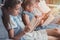 multicultural group of focused children reading books while sitting on sofa