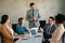 Multicultural professional businesspeople working together on research plan in boardroom.