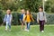 Multicultural schoolkids walking with backpacks on