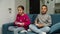 Multiethnic boy and girl playing video game, sitting on couch indoors