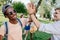 Multiethnic boys giving high five while meeting in park