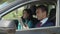 Multiethnic business couple works together in car