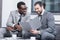 multiethnic businessmen smiling and reading document