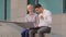 Multiethnic colleagues Caucasian woman and arabic Hispanic man sitting outdoors looking in laptop successful win