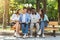 Multiethnic college friends resting in campus outdoors, using laptop together