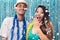 Multiethnic couple costumed for the Carnaval. Woman is frightened by the rain of confetti..