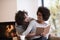 Multiethnic couple hugging in front of fireplace