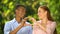 Multiethnic couple making hand heart gesture outdoor, first relations, love