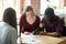 Multiethnic couple signing house purchase agreement.