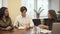 Multiethnic couple signing mortgage contract in realtor office.