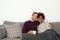 Multiethnic couple sitting on couch hugging