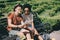 multiethnic couple of young tourists sitting on bench with digital